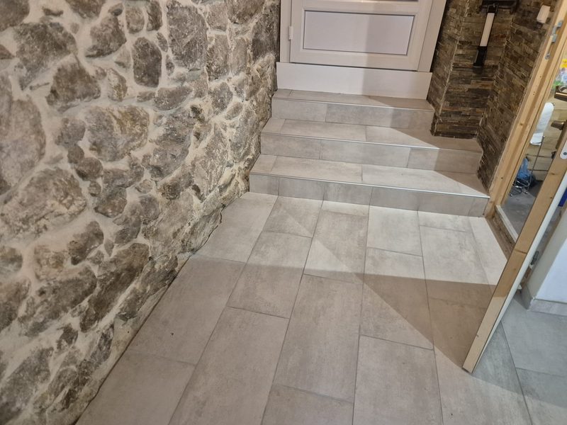 Entrée avec mur en pierre et carrelage neuf — D.M.S