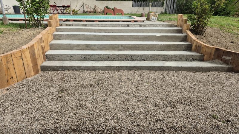 Escalier béton menant à une piscine, bordures bois et terrassement — D.M.S