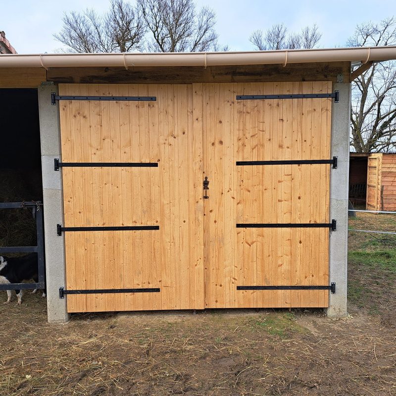 Porte de grange bois avec ferrures noires — menuiserie D.M.S